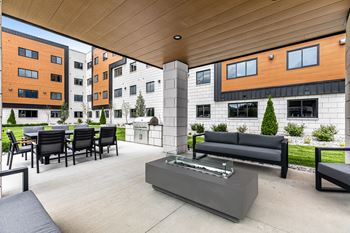 the terrace of a building with a fire pit and patio furniture